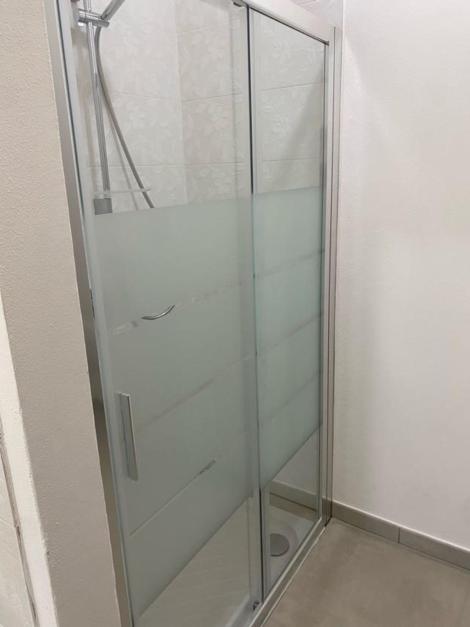 a glass shower stall in a white room at La Campanula-exclusive pool in Santa Maria a Monte