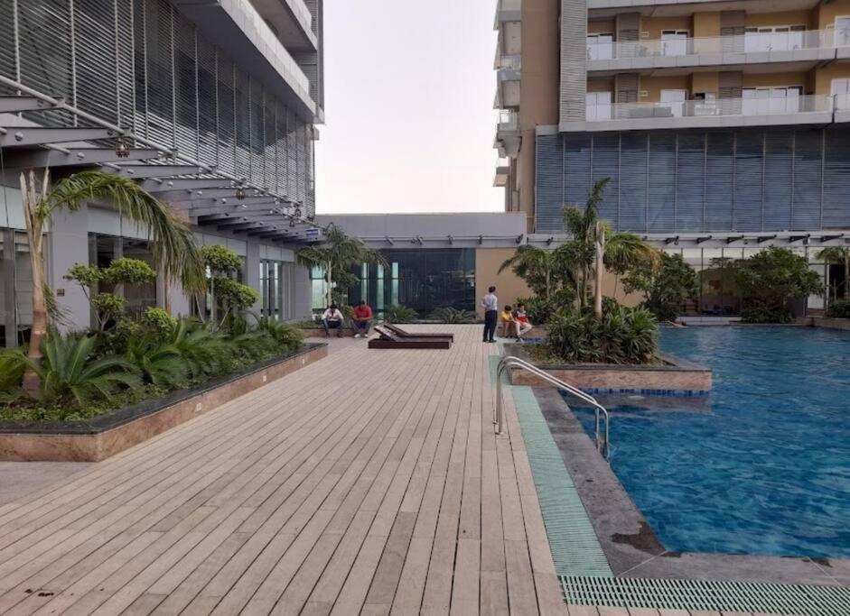 un edificio con piscina al lado de un edificio en SkyHigh Serenity. 2 Bhk Apartment. 0 Km From Delhi, en Noida