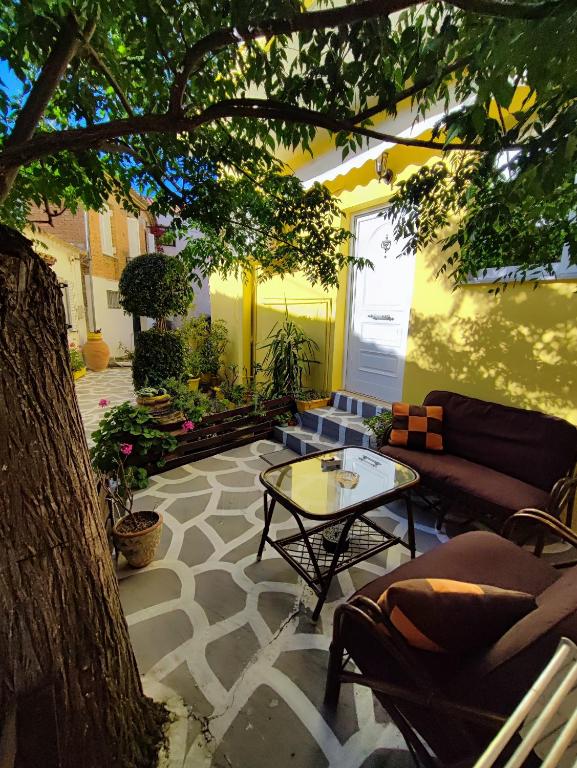 a patio with couches and a table and a tree at Summer studios 1 in Koroni