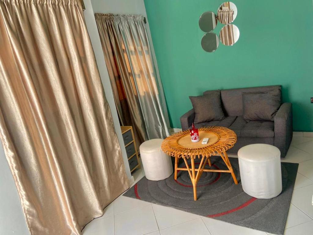 uma sala de estar com uma mesa e um sofá em Plage Ewell em Cotonou