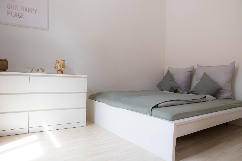ein Schlafzimmer mit einem weißen Bett und einer Kommode in der Unterkunft City Life Zentrum Zwickau in Zwickau