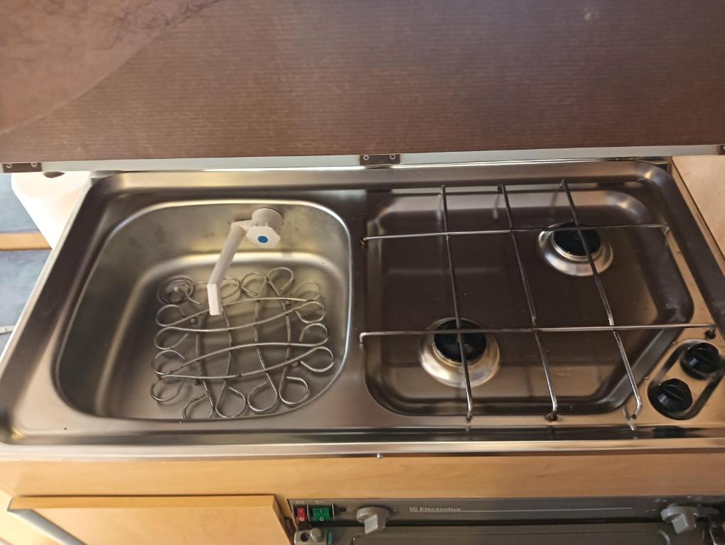 a stove top oven with a metal grate in it at Caravana Magic in Tindaya