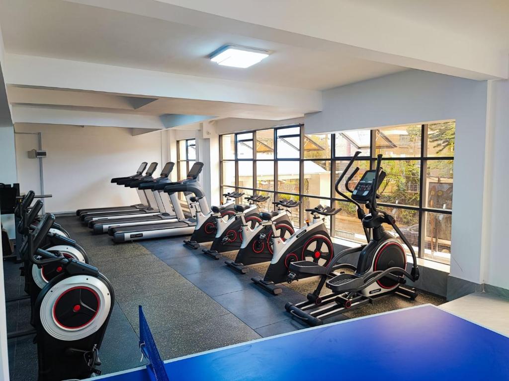 a gym with rows of treadmills and elliptical machines at Smarthomes Apartment in Nairobi
