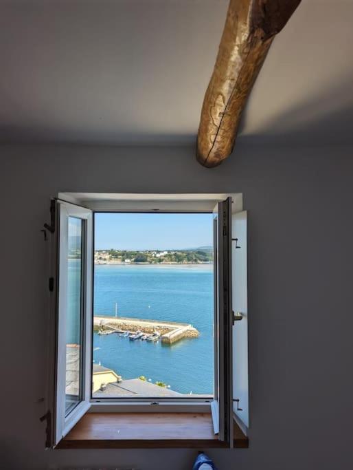 a window with a view of a body of water at Casa Buenos Aires in Ribadeo