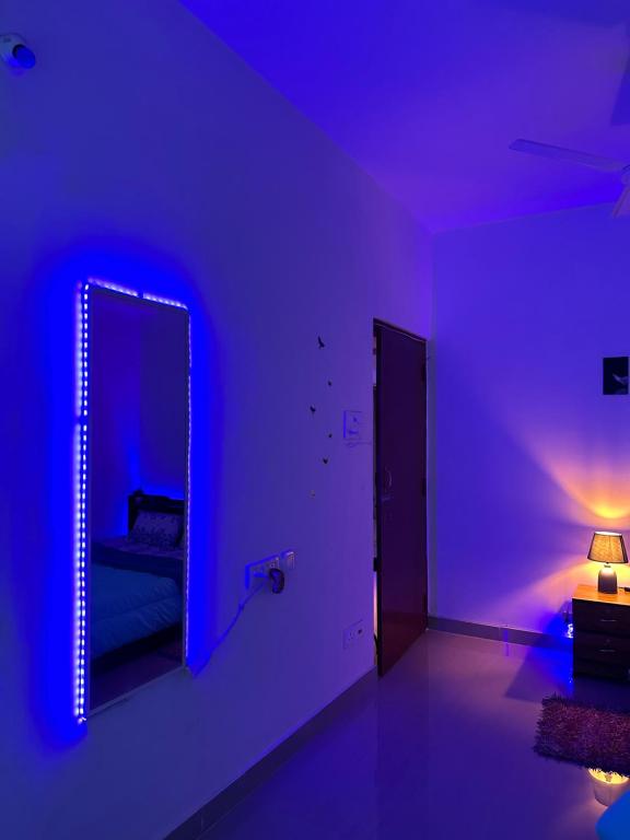 Habitación púrpura con espejo y lámpara en Pearl villa homestay, en Jorhāt