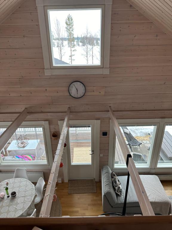 a living room with a clock on the ceiling at Villa Ihanus 100 m2 ja rantasauna järven rannalla in Kuusamo