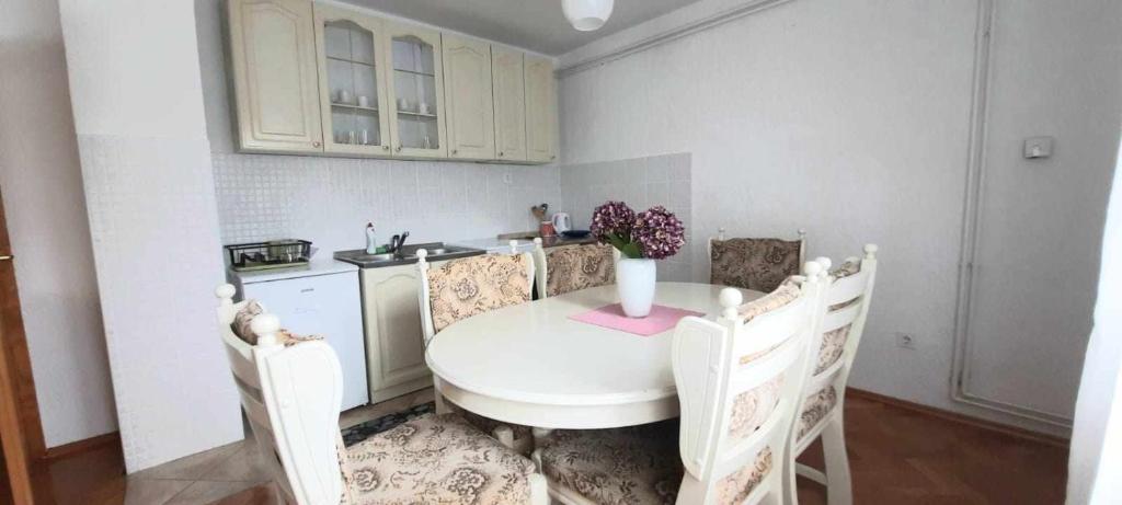a kitchen with a table with a vase of flowers on it at Dream in Otočac