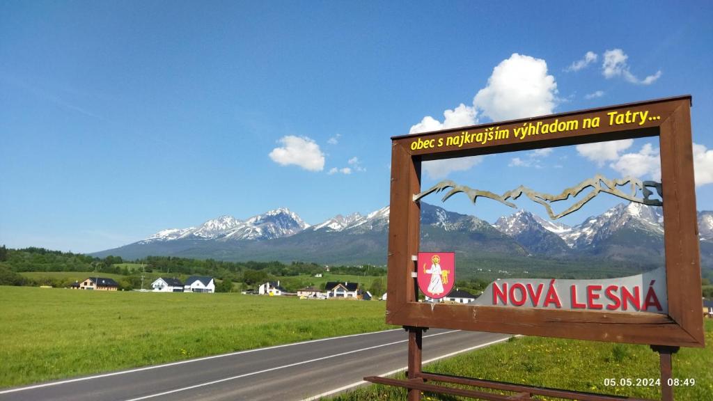 un cartello sul lato di una strada con montagne sullo sfondo di Lucky Cat a Nová Lesná