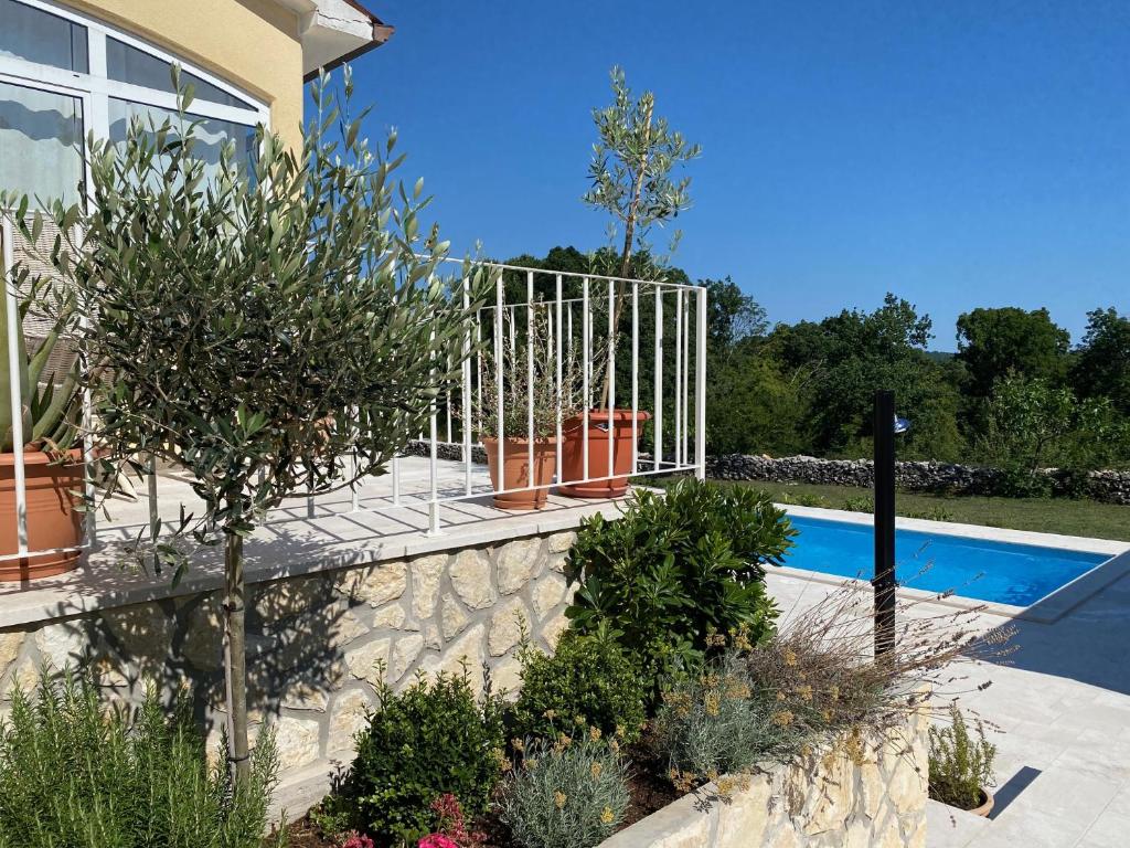 a swimming pool with a fence next to a house at Villa Yucca Istra in Labin