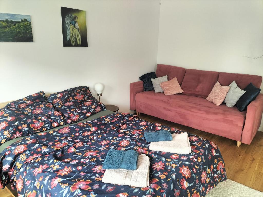 a living room with a bed and a couch at Kwatera Paprotka 23 in Warsaw
