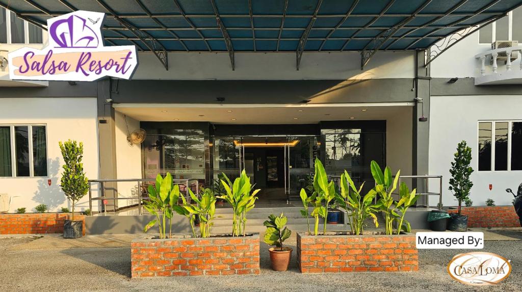 a restaurant with plants in front of a building at Salsa Resort Langkawi By Casa Loma in Pantai Cenang