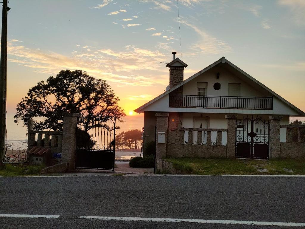 una vecchia casa con il tramonto sullo sfondo di Apartamento Loft A Estivada a Rosal