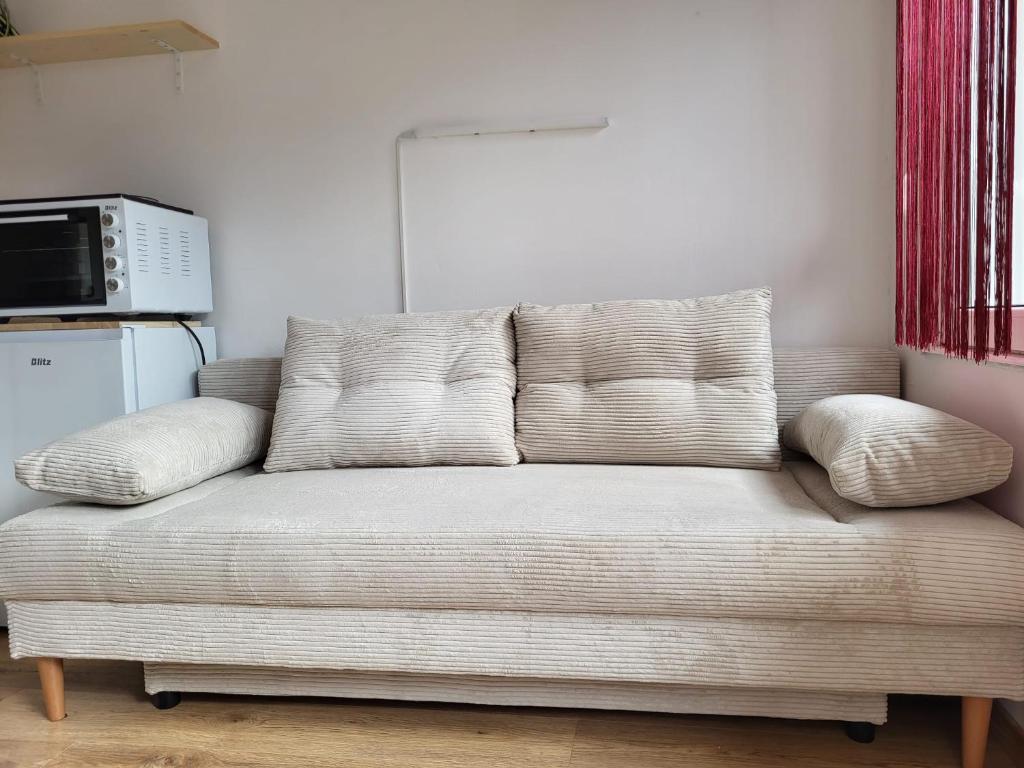 ein Sofa im Wohnzimmer mit Mikrowelle in der Unterkunft Rebro apartman in Zagreb