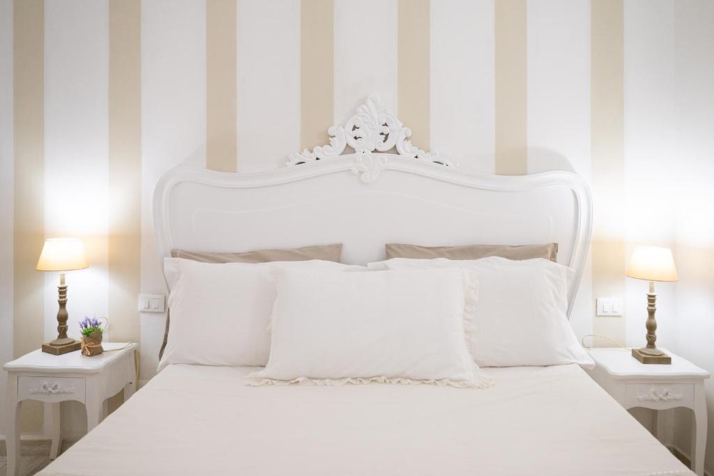 Dormitorio blanco con cama blanca y almohadas blancas en La Casa del Viandante, en La Spezia