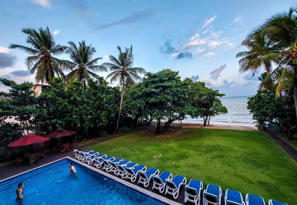 einen Pool mit Stühlen und Meerblick in der Unterkunft Golden Pearl Tangalle Beach New in Hambantota