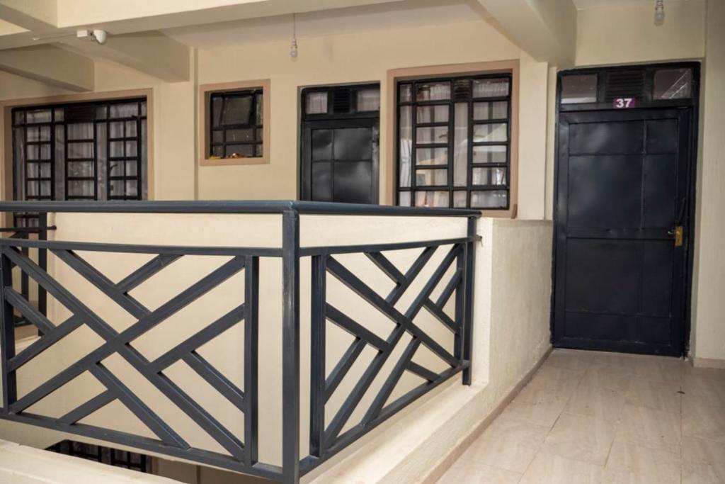 two doors in a room with a balcony with wooden floors at snazzy guest house in Nakuru