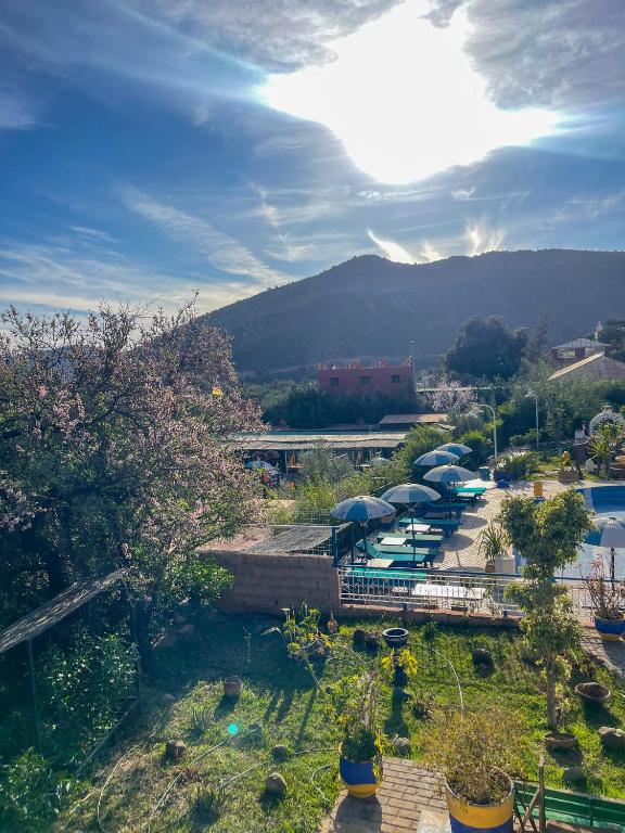 a view of a park with umbrellas and a pool at Auberge le Refuge in Agadir
