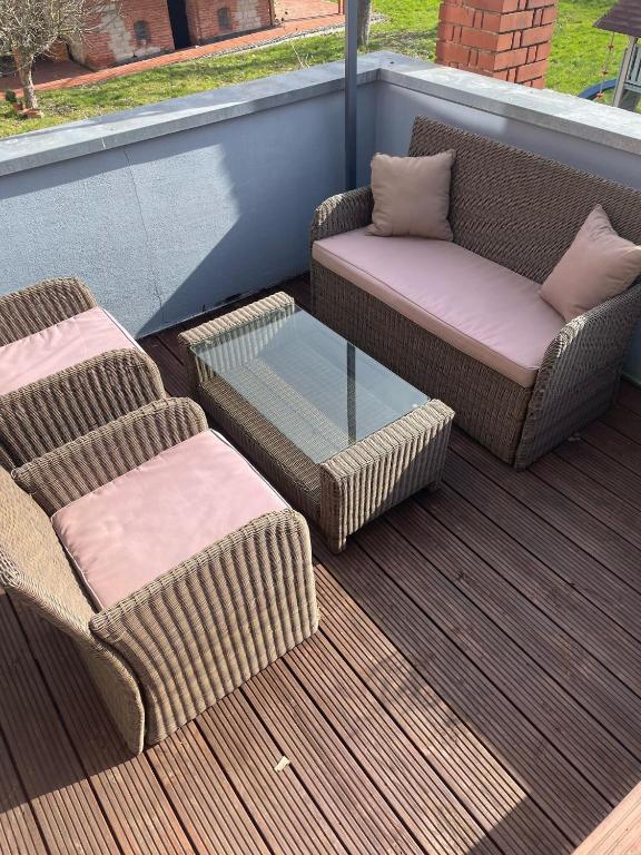 a patio with two chairs and a couch and a glass table at Gemütliche Ferienwohnung der Familie Hüther in Göttingen