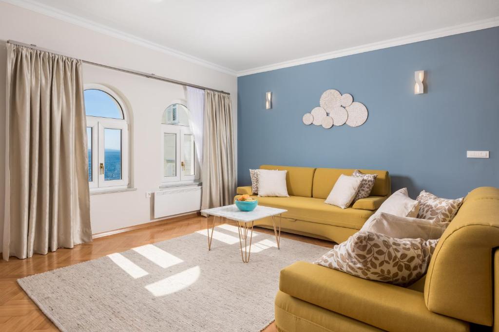 een woonkamer met een bank en een tafel bij Apartment Marina -1st row to the sea in Opatija