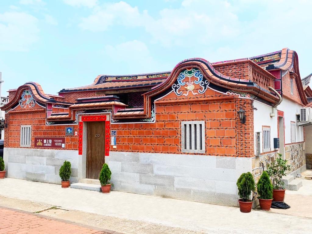 un edificio de ladrillo rojo con puerta roja en King of Thailand en Jinhu