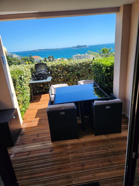 un patio avec une table, des chaises et un barbecue dans l'établissement Appartement vue mer, à Cannes