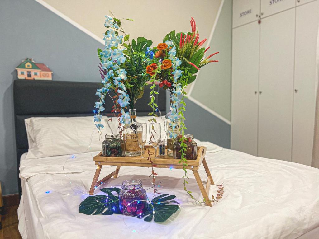 a table with flowers and other items on a bed at Balakong,1-7pax,Cozy Studio,Near Dataran C180 in Cheras