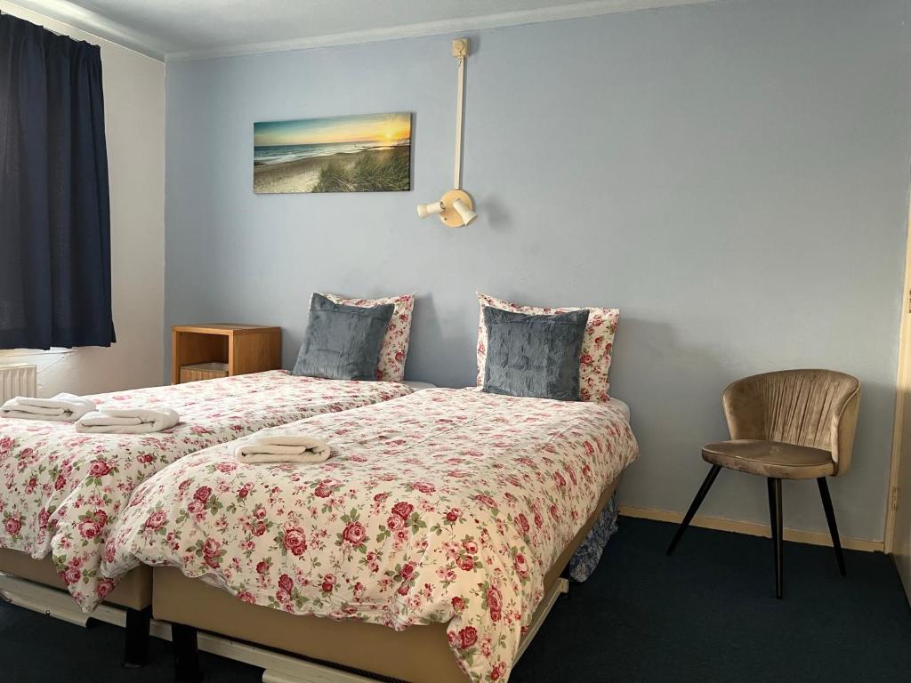 1 dormitorio con 1 cama y 1 silla en Hotel Noordzee, en Zandvoort