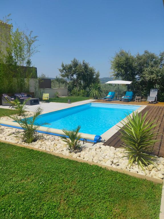- une piscine dans une cour avec une terrasse en bois dans l'établissement Villa Josiol Mirabel aux Baronnies, à Mirabel-aux-Baronnies