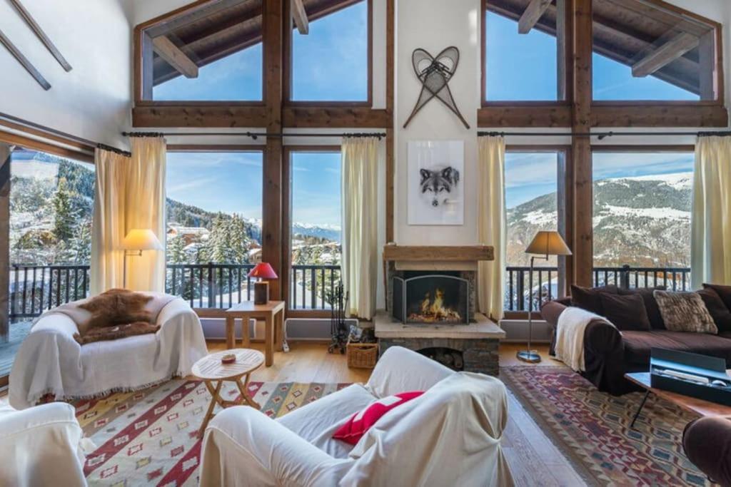 uma sala de estar com lareira e janelas grandes em 200m ski slopes - Chalet Manora - Courchevel La Tania em Courchevel