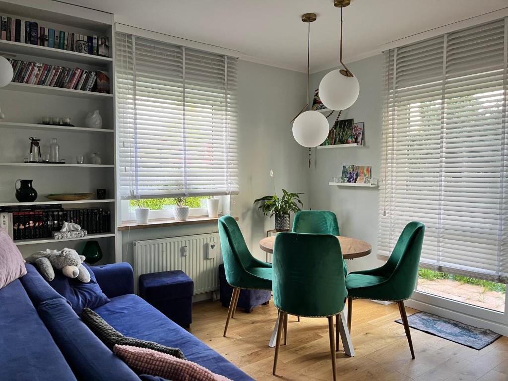 a living room with a blue couch and a table and chairs at Apartament Zakoniczyn in Gdańsk