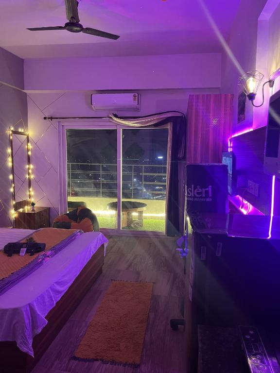 a bedroom with a bed and a window with purple lights at Bella Dreamy near expo mart greater Noida in Greater Noida
