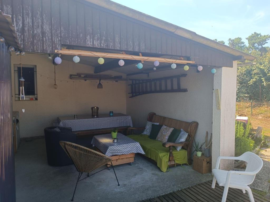 - une terrasse avec un lit, une table et des chaises dans l'établissement Villa Ilanga, à Soulac-sur-Mer