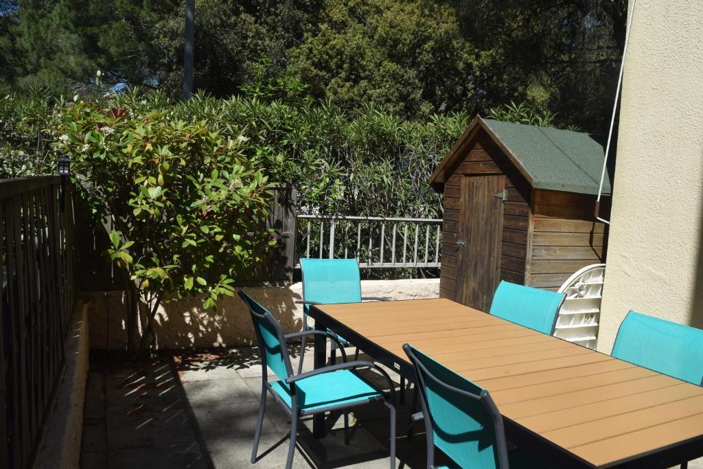 une table et des chaises en bois et une niche pour chien dans l'établissement T2 climatisé à 500m de la plage sur la presqu'ile de Saint Mandrier sur Mer, à Saint-Mandrier-sur-Mer
