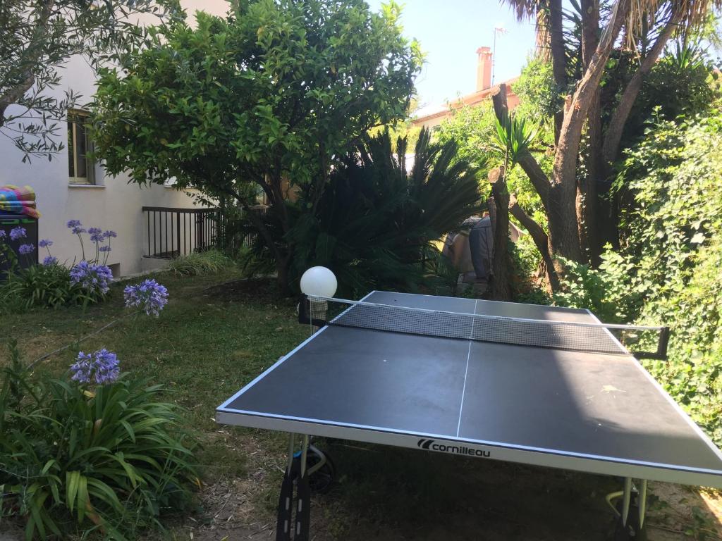 a ping pong table in a yard with a tennis court at Camélias - Chambre privée, proche mer in Antibes