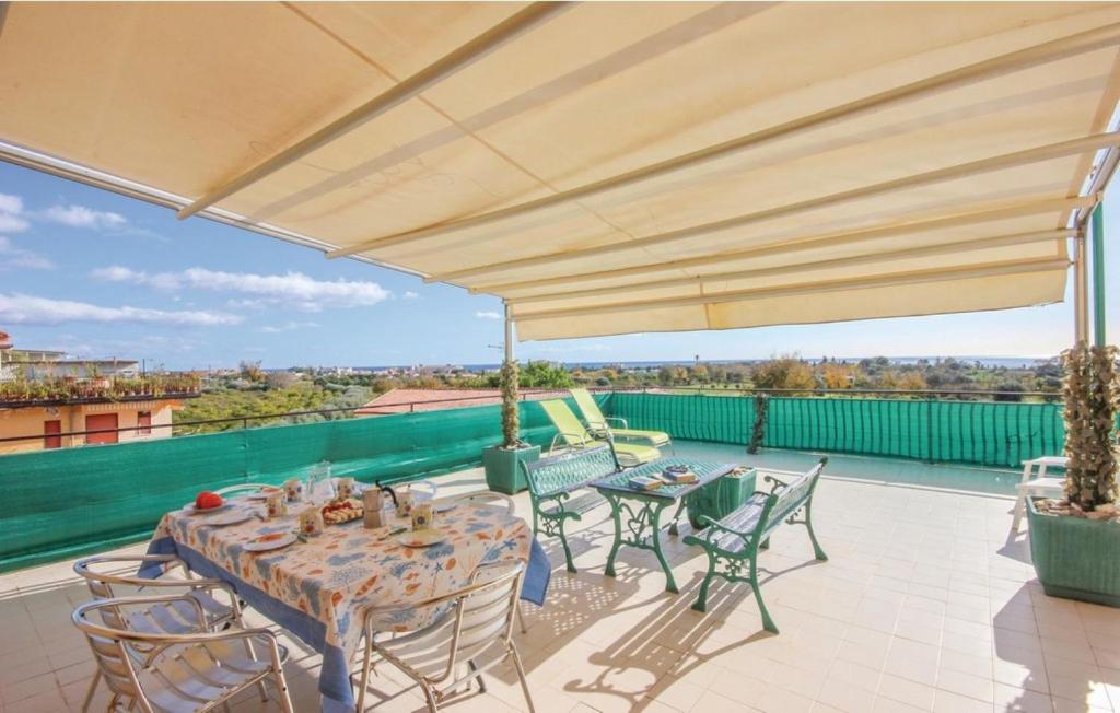 a patio with a table and chairs and a large umbrella at Appartamenti Calliope e Silvia, Giardini Naxos in Giardini Naxos