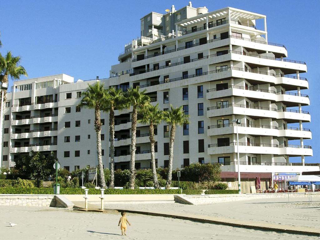 a person walking in front of a large building at Apartamentos Topacio Unitursa in Calpe