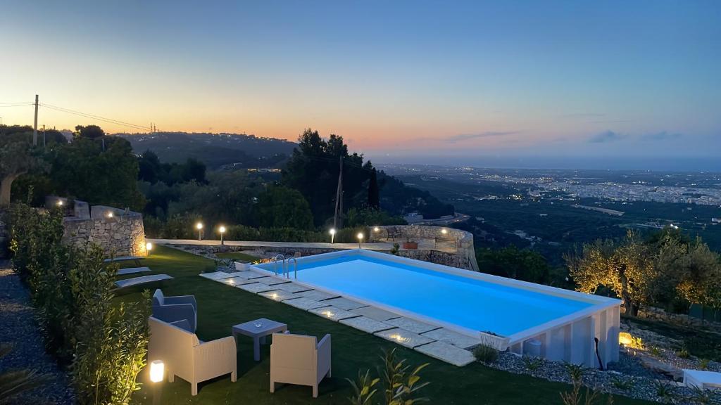 une villa avec une piscine au crépuscule dans l'établissement Trulli Belvedere di Puglia, à Selva di Fasano