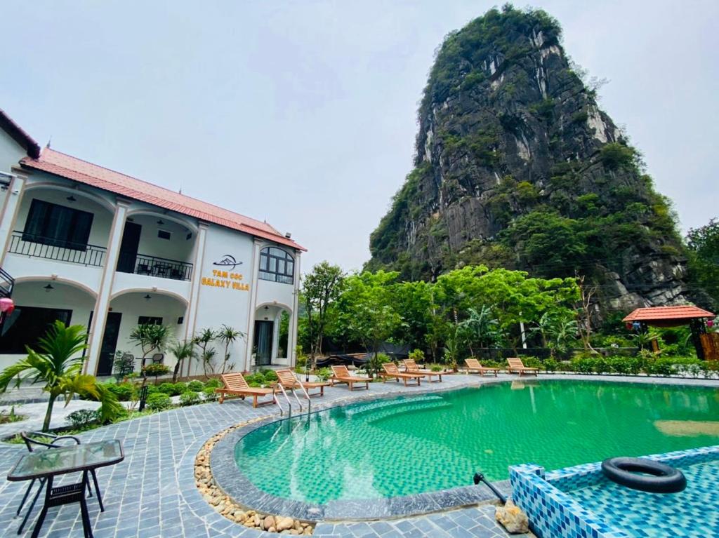 ein Pool in einem Resort mit einem Berg im Hintergrund in der Unterkunft Tam Coc Galaxy Villa in Ninh Bình