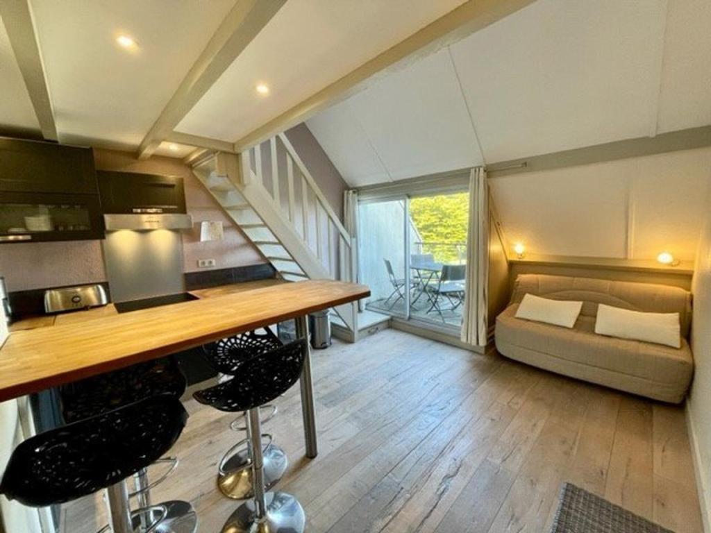 Una cocina y una sala de estar con una mesa y un sofá. en Studio mezzanine rénové 32m² avec balcon, parking et accès plage à Saint-Pierre-Quiberon - FR-1-478-82, en Saint-Pierre-Quiberon