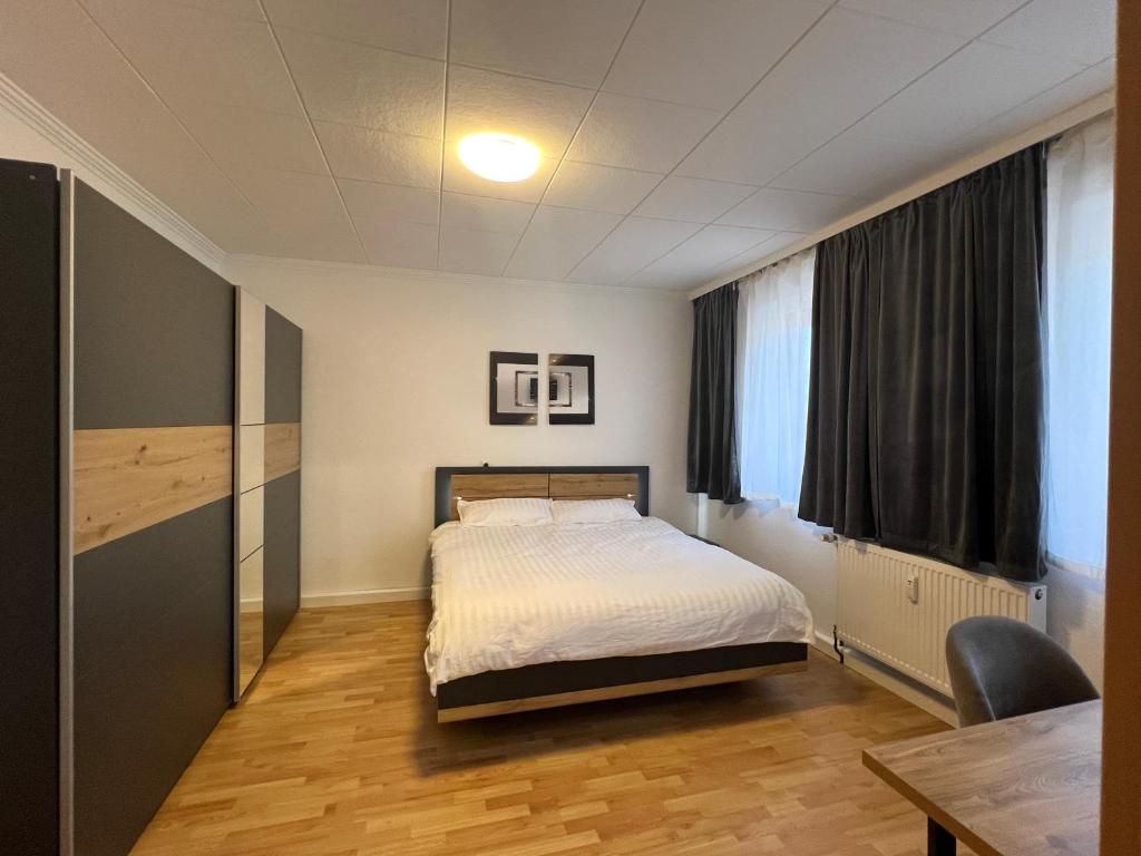 a bedroom with a bed and a desk and a table at Bequemes Zimmer in moderner Unterkunft My Pension Duisburg in Duisburg