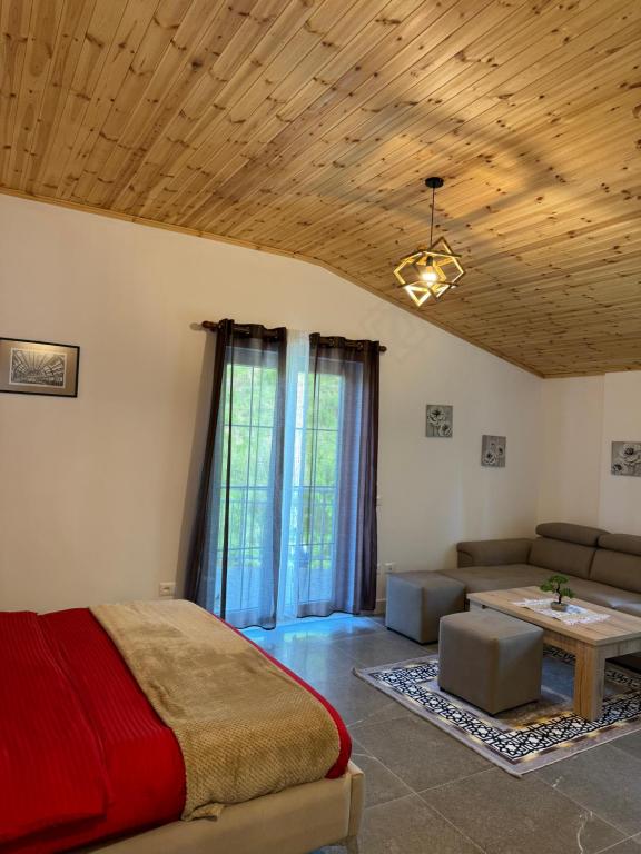 um quarto com uma cama, um sofá e uma mesa em Qyteza Guest House & Camping em Shkodër