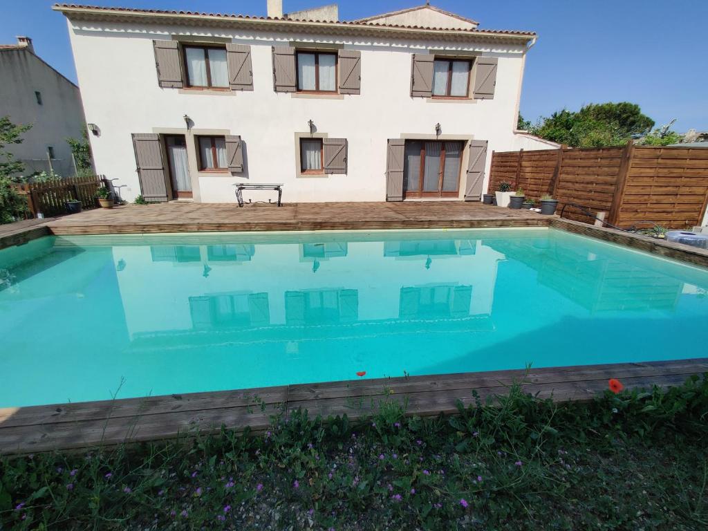 eine Villa mit einem Pool vor einem Haus in der Unterkunft Gîte du Charme Provençal in Sénas