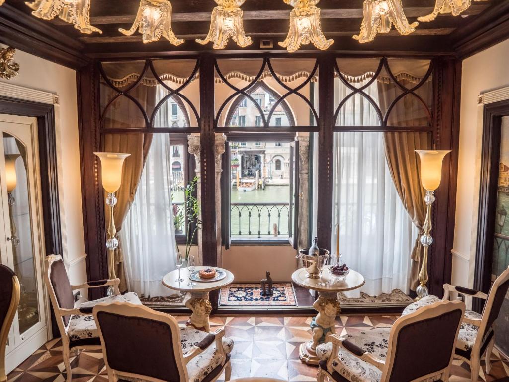 a room with a large window with chairs and tables at EGO' Boutique Hotel - The Silk Road in Venice