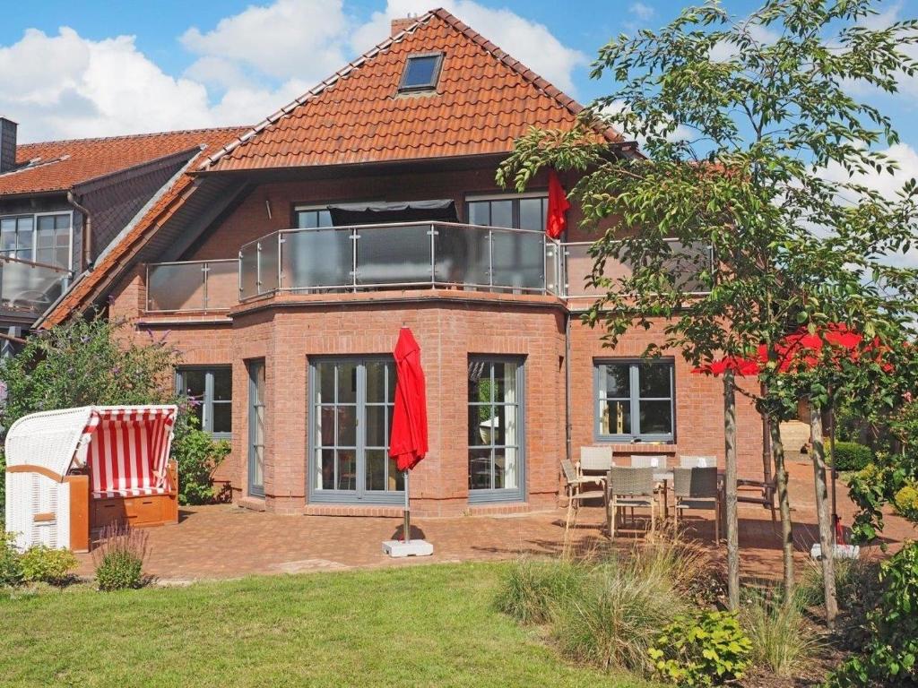 a house with a balcony and a table and chairs at Villa Seeblick am Strand in Flessenow