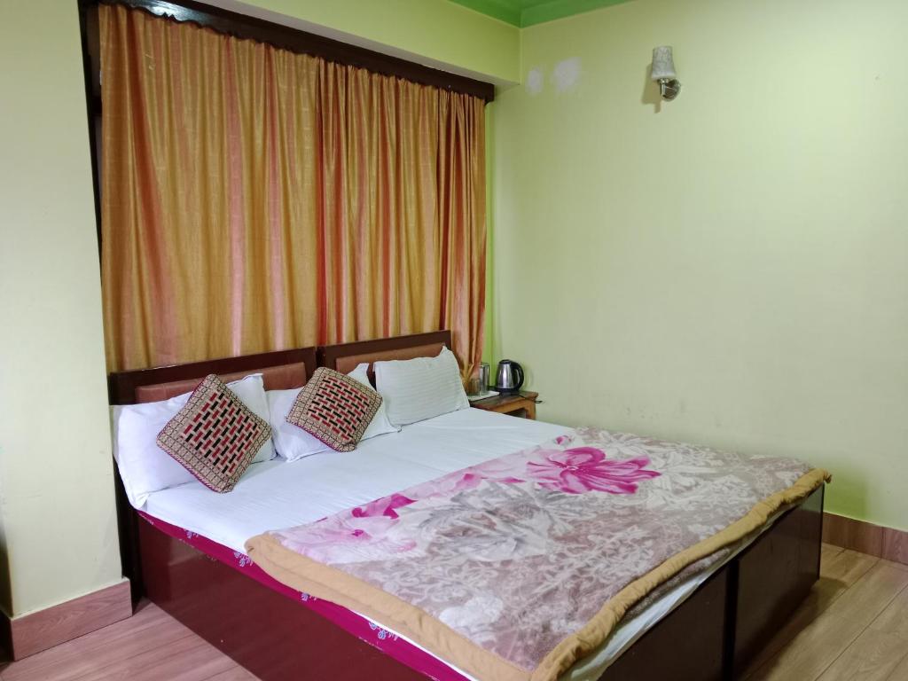 Un dormitorio con una cama con flores. en Zimkhang Guesthouse, en Gangtok