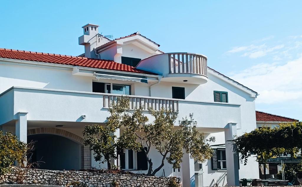 a white building with a balcony on top of it at Apartman Lucy in Slatine
