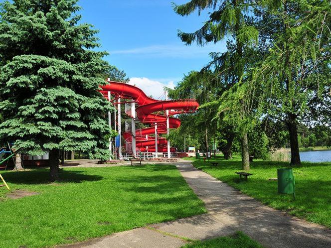 una montaña rusa roja en un parque con árboles en Warzkowizna, en Rząsawa