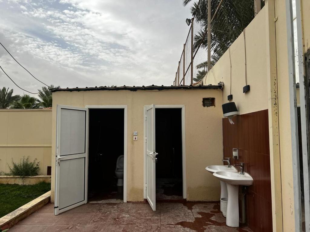 a bathroom with two doors and a sink next to a building at استراحة تل الشمال5 in Riyadh