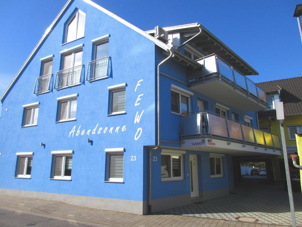 un bâtiment bleu avec un panneau sur son côté dans l'établissement Ferienwohnungen Abendsonne - 7 Gehminuten zum EP, à Rust
