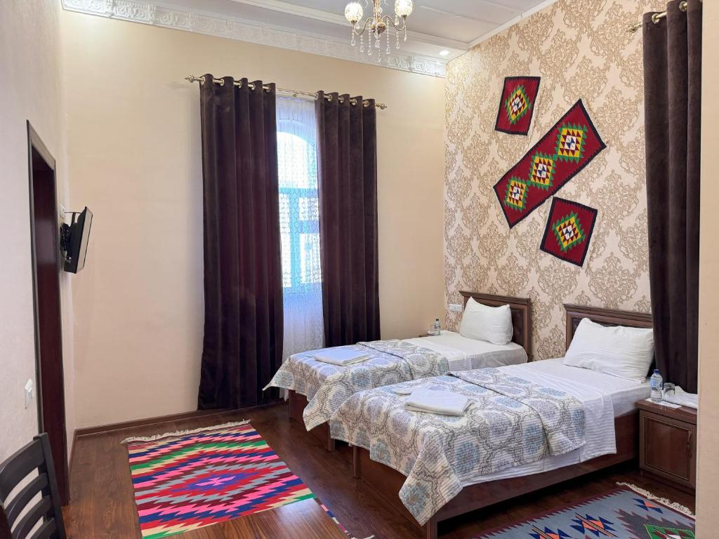um quarto com 2 camas e uma janela em M Hotel Khiva em Khiva